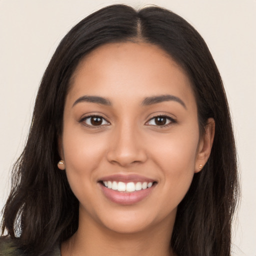 Joyful latino young-adult female with long  black hair and brown eyes