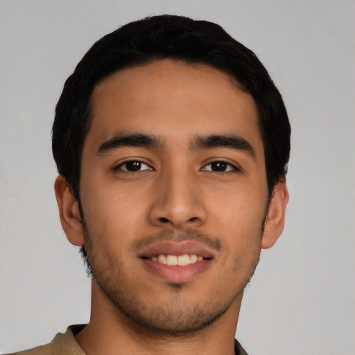 Joyful latino young-adult male with short  black hair and brown eyes