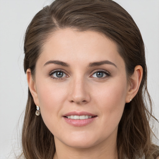 Joyful white young-adult female with long  brown hair and grey eyes