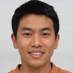 Joyful asian young-adult male with short  brown hair and brown eyes