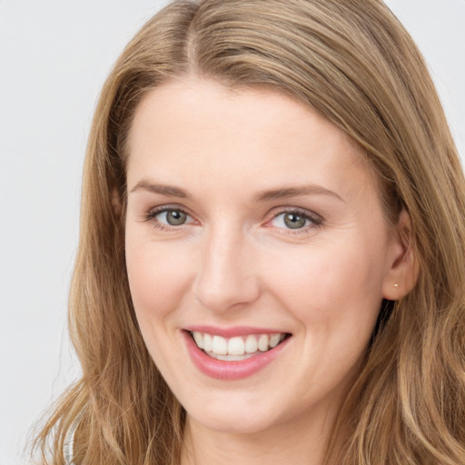 Joyful white young-adult female with long  brown hair and blue eyes