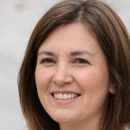 Joyful white adult female with long  brown hair and brown eyes