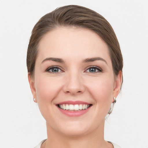 Joyful white young-adult female with medium  brown hair and grey eyes