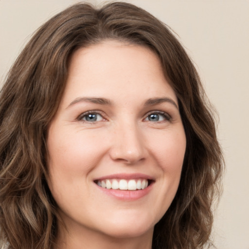 Joyful white young-adult female with long  brown hair and green eyes