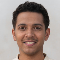 Joyful latino young-adult male with short  brown hair and brown eyes