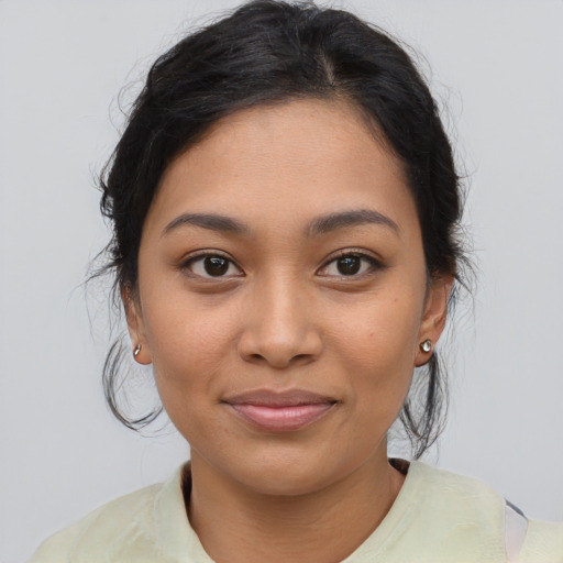 Joyful latino young-adult female with medium  brown hair and brown eyes