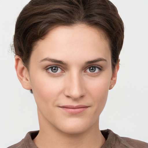 Joyful white young-adult female with short  brown hair and grey eyes