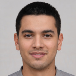 Joyful latino young-adult male with short  black hair and brown eyes