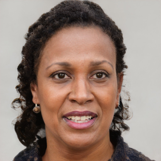 Joyful black adult female with long  brown hair and brown eyes