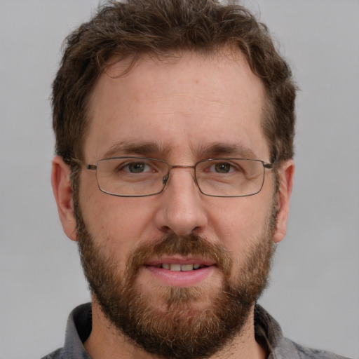 Joyful white adult male with short  brown hair and grey eyes