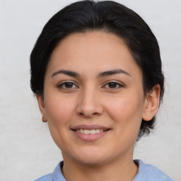 Joyful latino young-adult female with medium  brown hair and brown eyes