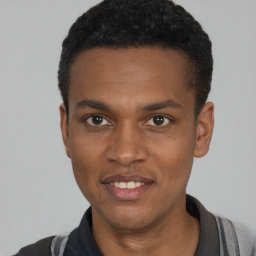 Joyful black young-adult male with short  black hair and brown eyes