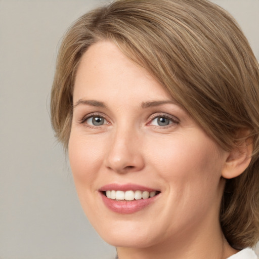 Joyful white young-adult female with medium  brown hair and blue eyes