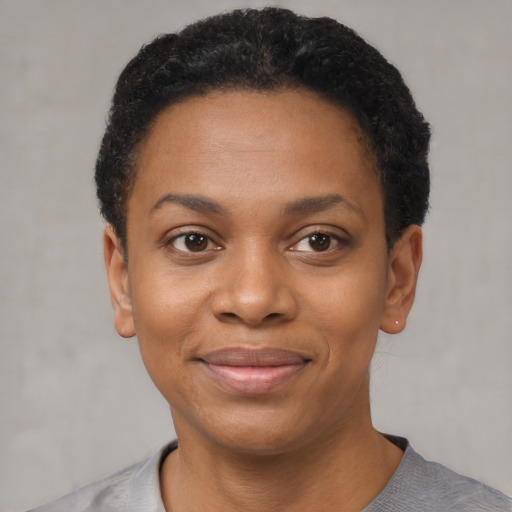 Joyful black young-adult female with short  black hair and brown eyes