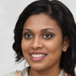 Joyful black young-adult female with long  brown hair and brown eyes