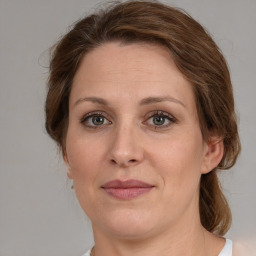 Joyful white adult female with medium  brown hair and green eyes