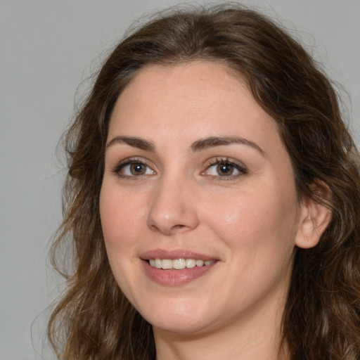 Joyful white young-adult female with long  brown hair and green eyes