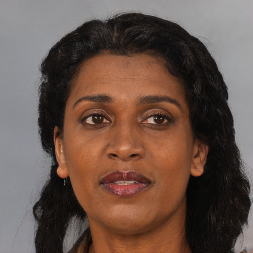 Joyful black adult female with medium  brown hair and brown eyes