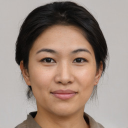 Joyful asian young-adult female with medium  brown hair and brown eyes