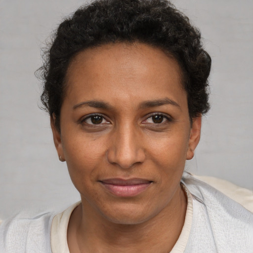Joyful black young-adult female with short  brown hair and brown eyes