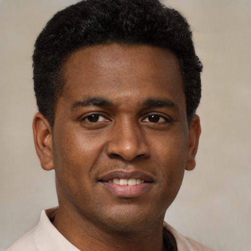 Joyful black young-adult male with short  brown hair and brown eyes