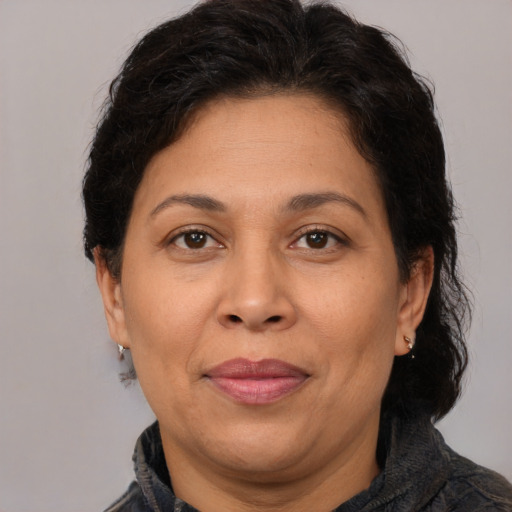 Joyful latino adult female with medium  brown hair and brown eyes