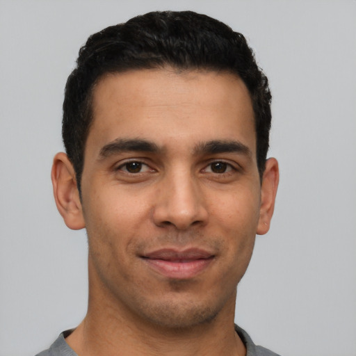 Joyful latino young-adult male with short  black hair and brown eyes