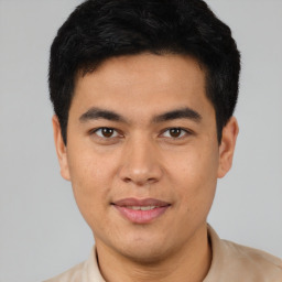 Joyful latino young-adult male with short  black hair and brown eyes