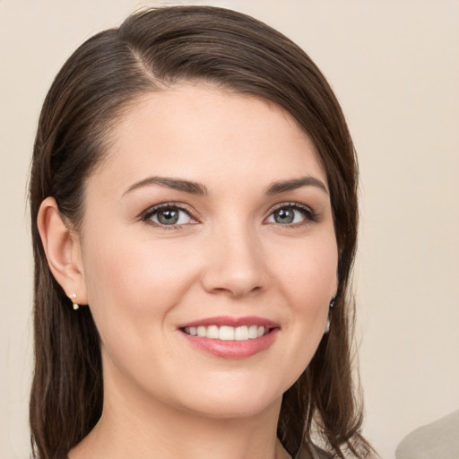 Joyful white young-adult female with medium  brown hair and grey eyes