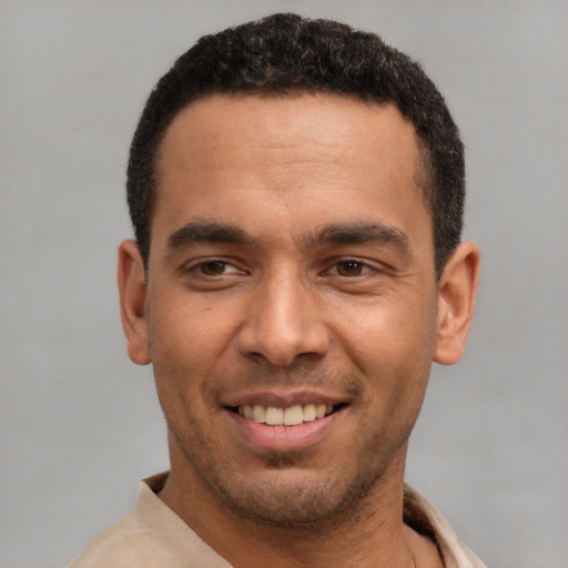 Joyful latino young-adult male with short  black hair and brown eyes