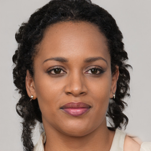 Joyful black young-adult female with medium  brown hair and brown eyes