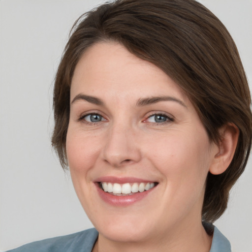 Joyful white young-adult female with medium  brown hair and green eyes