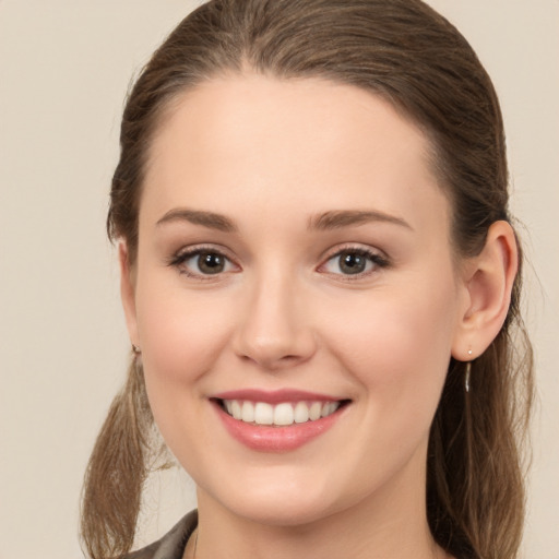 Joyful white young-adult female with long  brown hair and green eyes