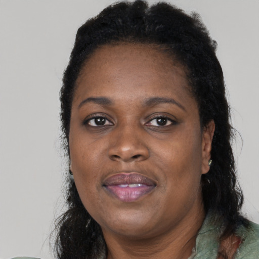 Joyful black adult female with long  black hair and brown eyes