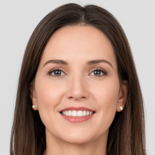 Joyful white young-adult female with long  brown hair and grey eyes