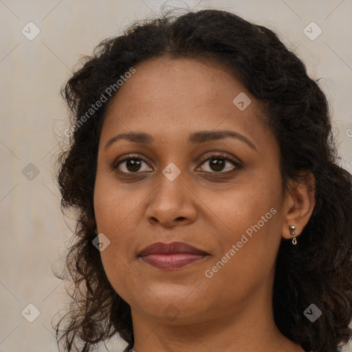 Joyful black adult female with long  brown hair and brown eyes