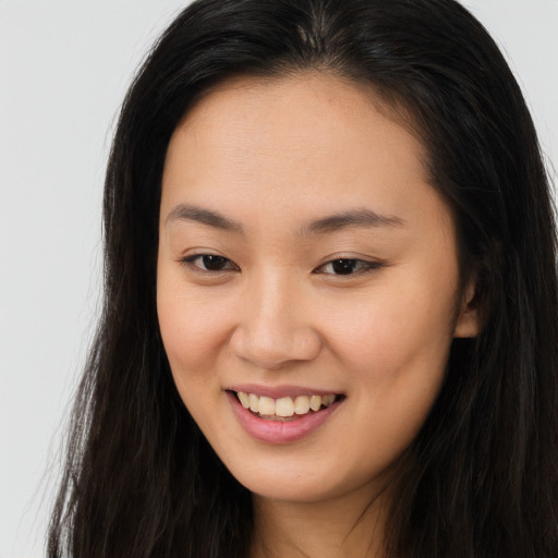 Joyful asian young-adult female with long  brown hair and brown eyes