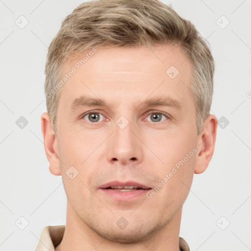 Joyful white young-adult male with short  brown hair and grey eyes