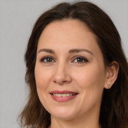 Joyful white adult female with long  brown hair and brown eyes