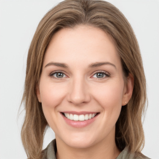 Joyful white young-adult female with long  brown hair and green eyes