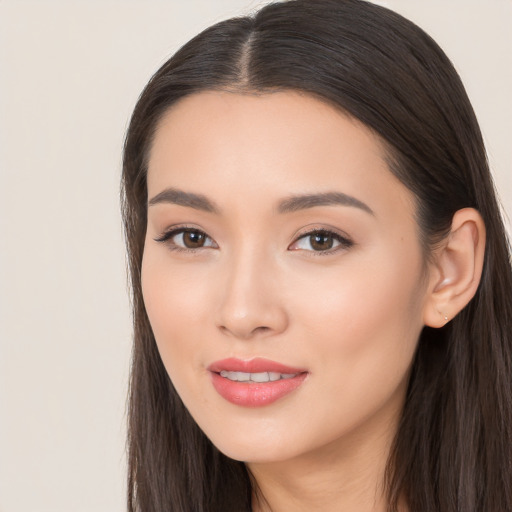 Joyful asian young-adult female with long  brown hair and brown eyes