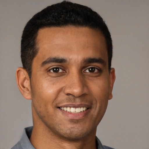 Joyful latino young-adult male with short  black hair and brown eyes