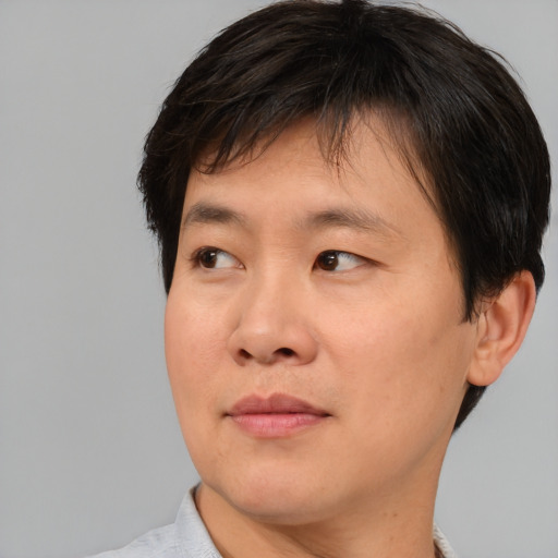 Joyful asian young-adult male with short  brown hair and brown eyes