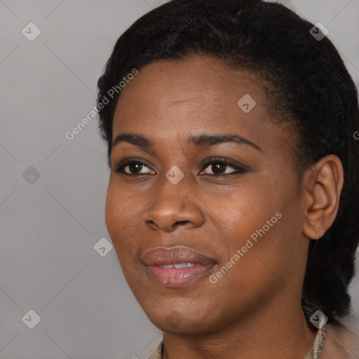Joyful black young-adult female with short  black hair and brown eyes