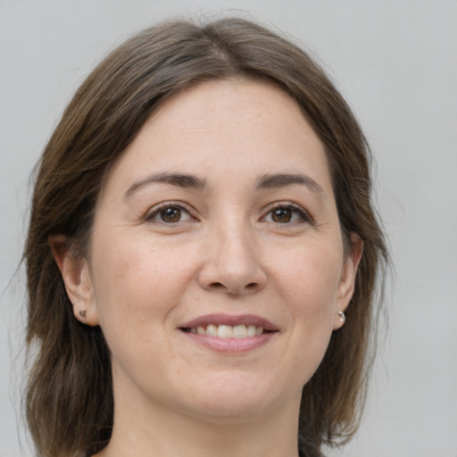 Joyful white adult female with medium  brown hair and grey eyes