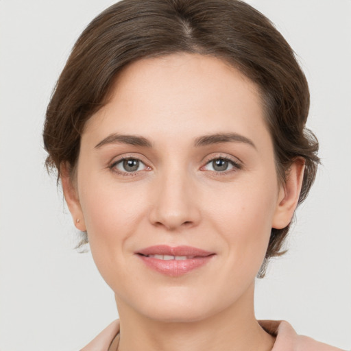 Joyful white young-adult female with medium  brown hair and grey eyes