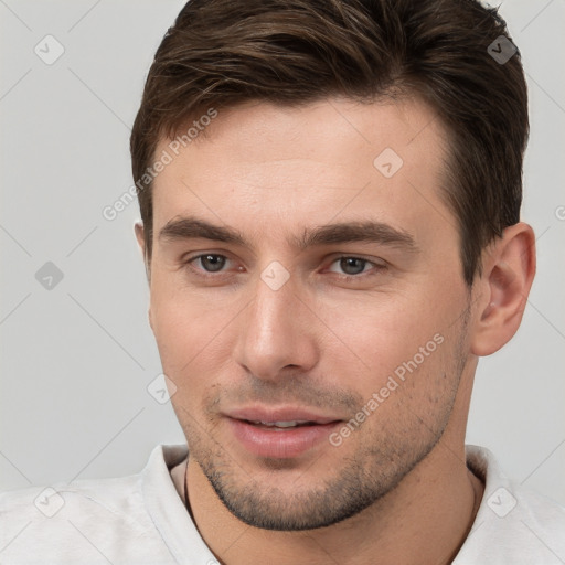 Joyful white young-adult male with short  brown hair and brown eyes