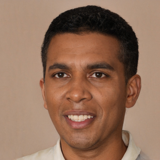 Joyful black young-adult male with short  black hair and brown eyes