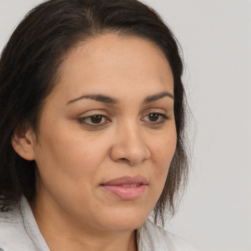 Joyful latino adult female with medium  brown hair and brown eyes