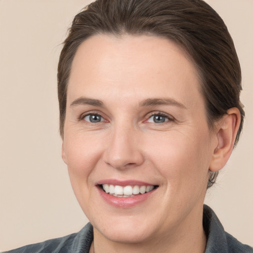 Joyful white adult female with medium  brown hair and brown eyes